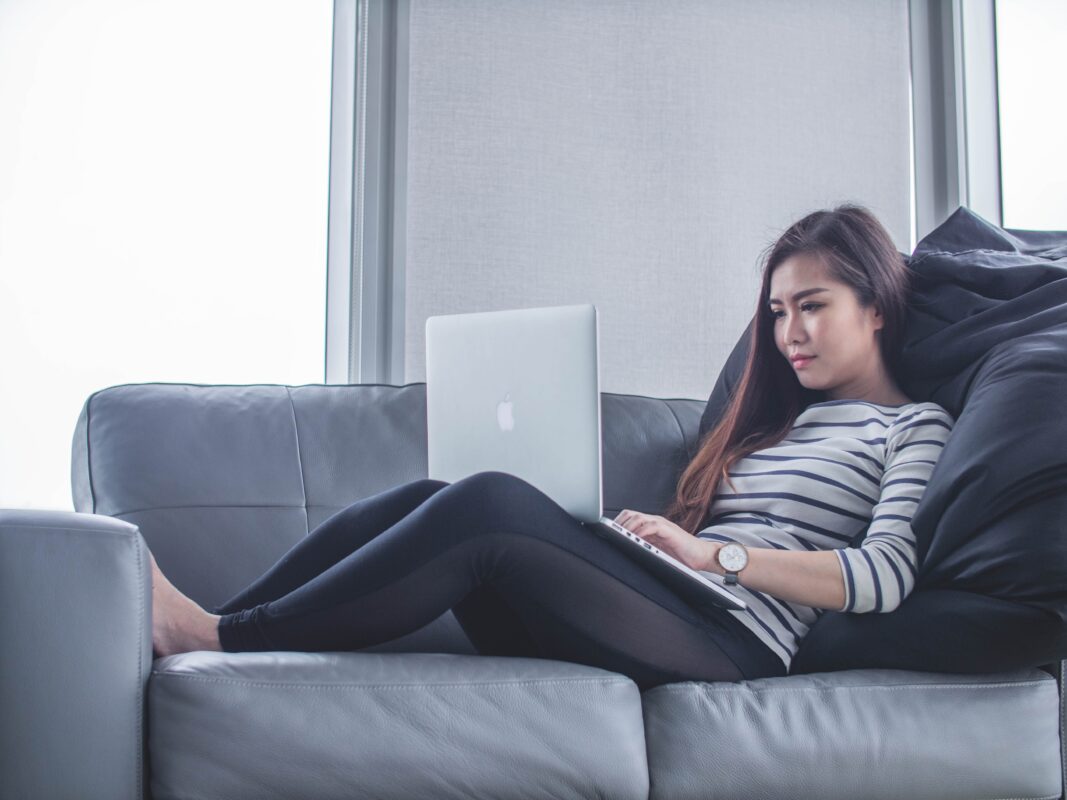 woman on sofa with laptop considering 40-year mortgage