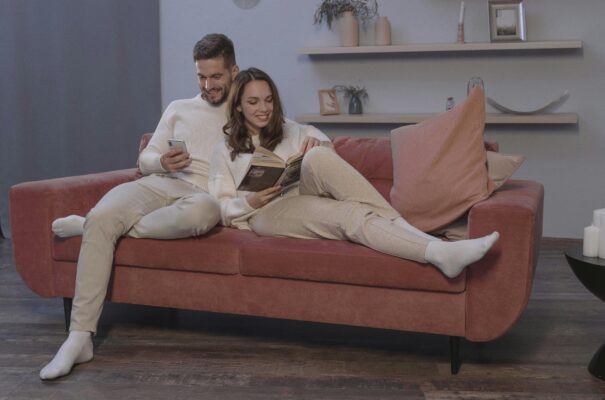 young couple sat happily on a pink sofa