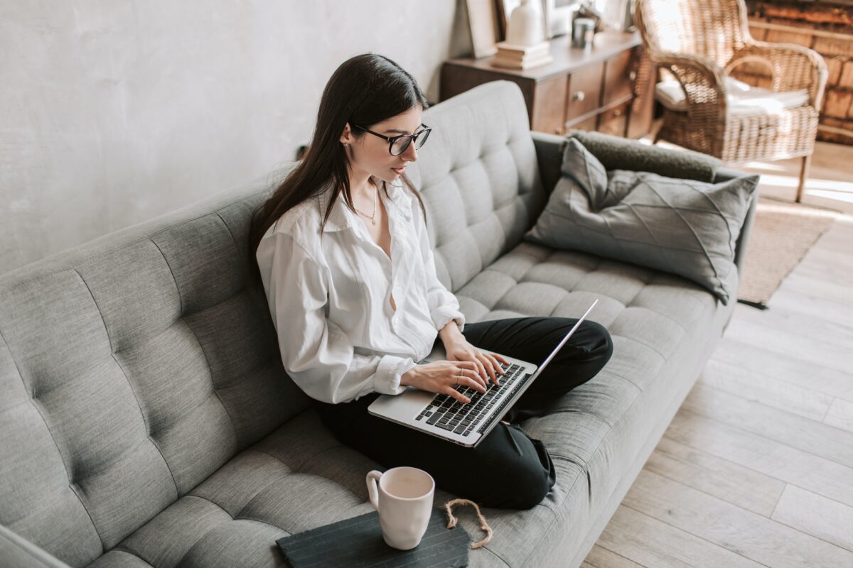 Woman on sofa with laptop securing her ideal mortgage