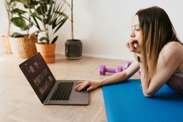 young woman on yoga mat at laptop payday loan mortgage