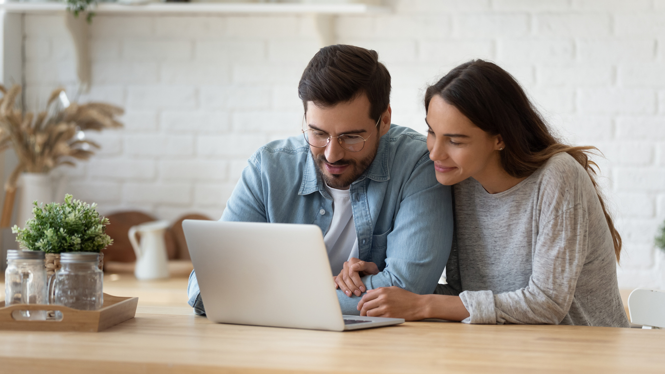 Young male and female couple looking at a laptop together