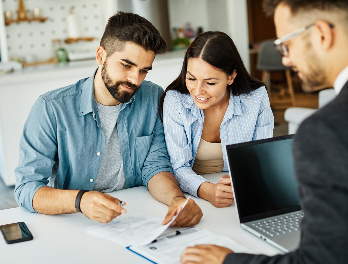 Young male and female couple looking happy sat with a professional getting their AIP