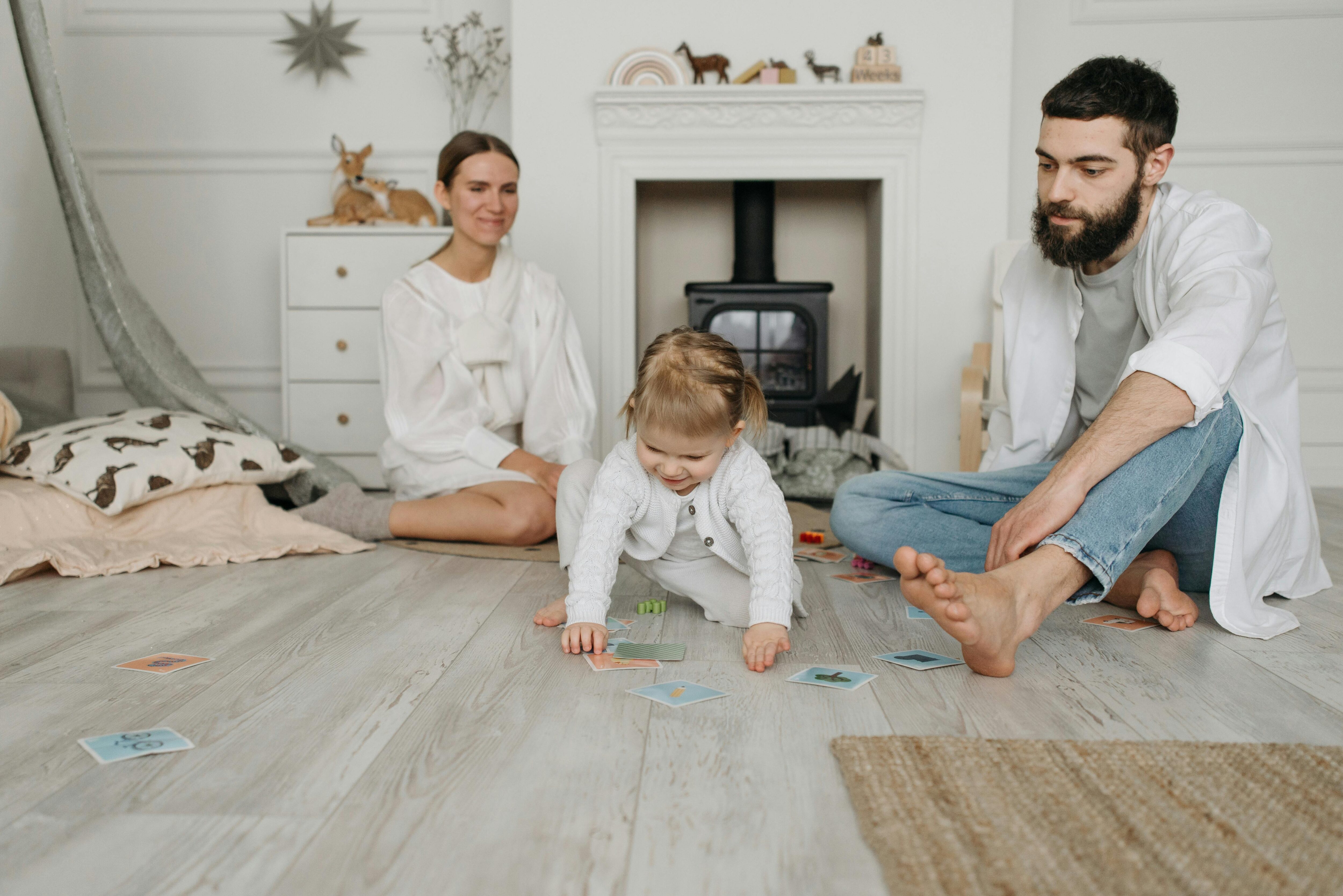 Young family with man, woman and baby in front of a fireplace in a lounge