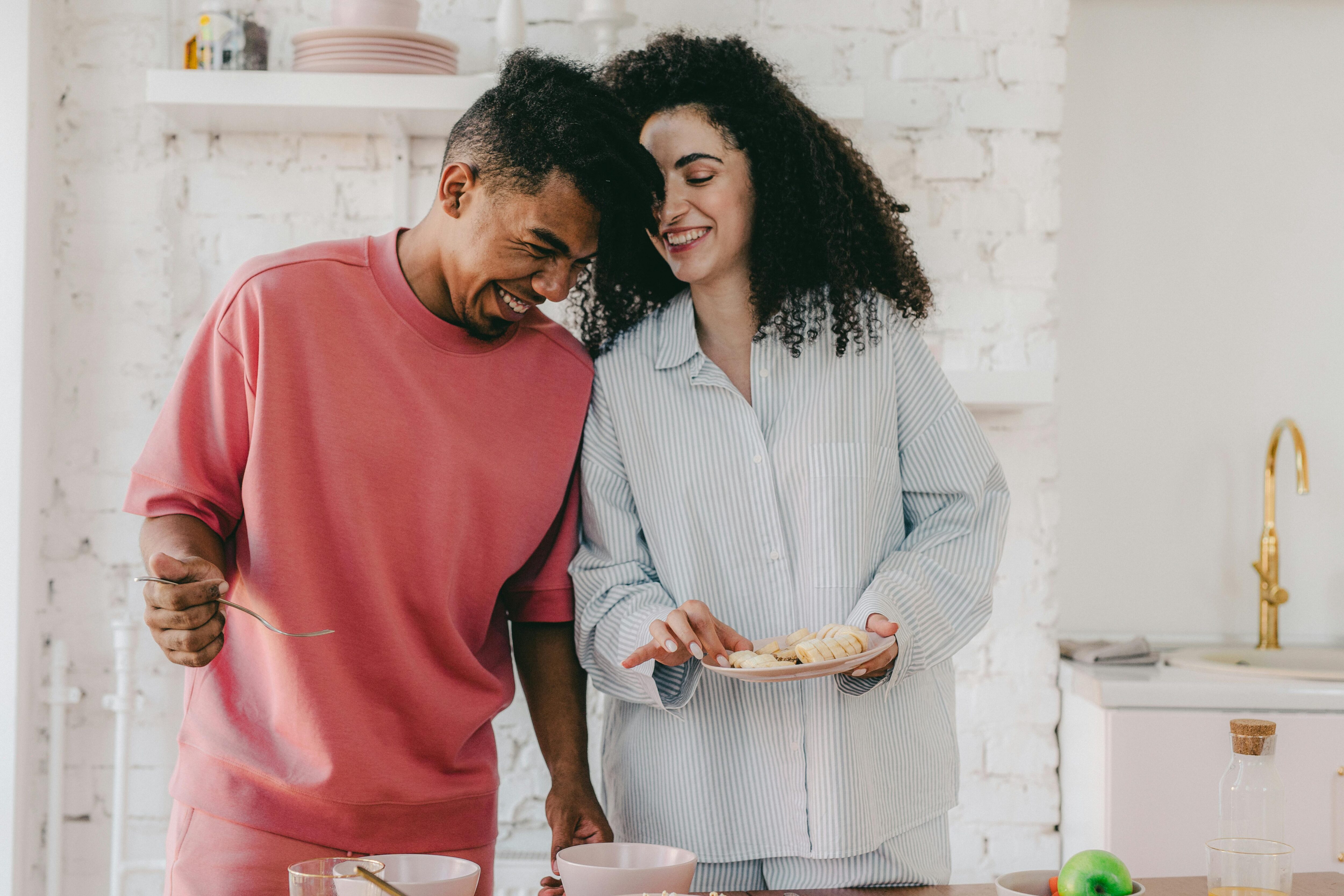 Young mixed race male and female couple happy in a kitchen